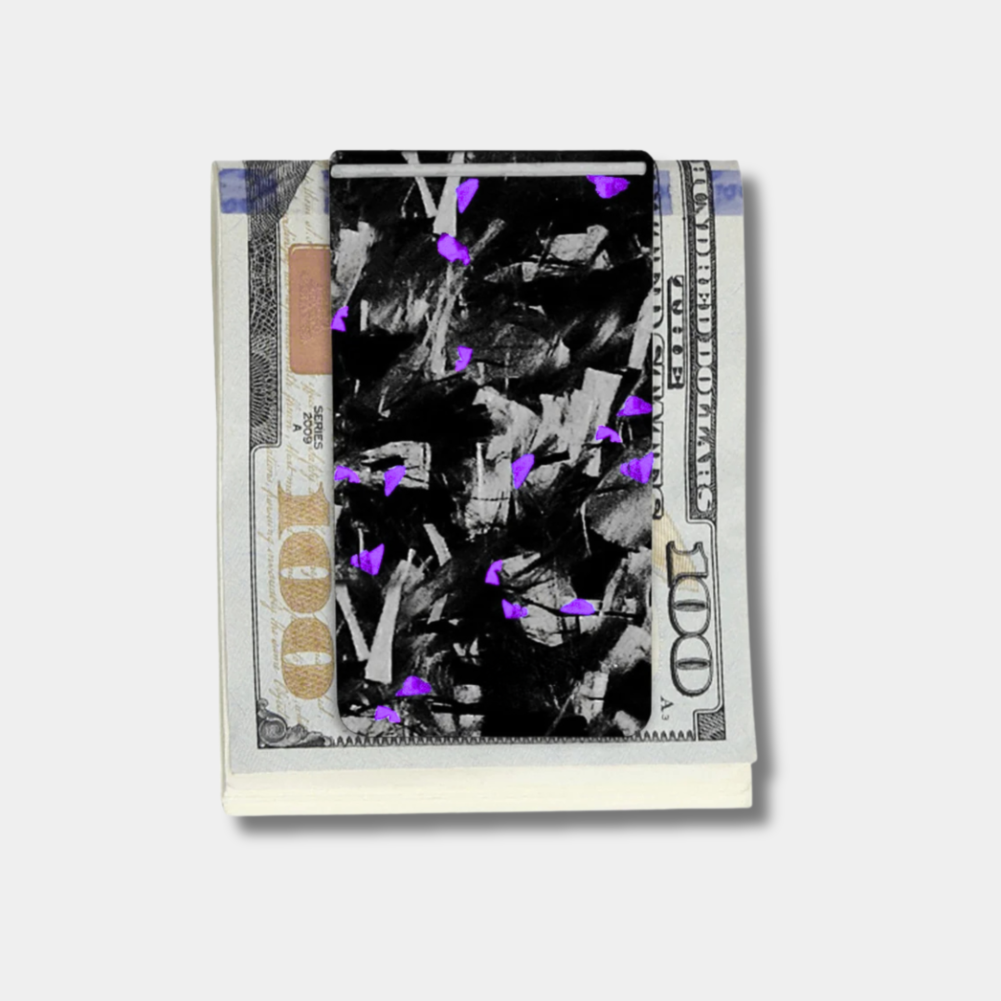 Forged Karbon™ money clip in black composite with purple accents holding bills by Karbon Technik.