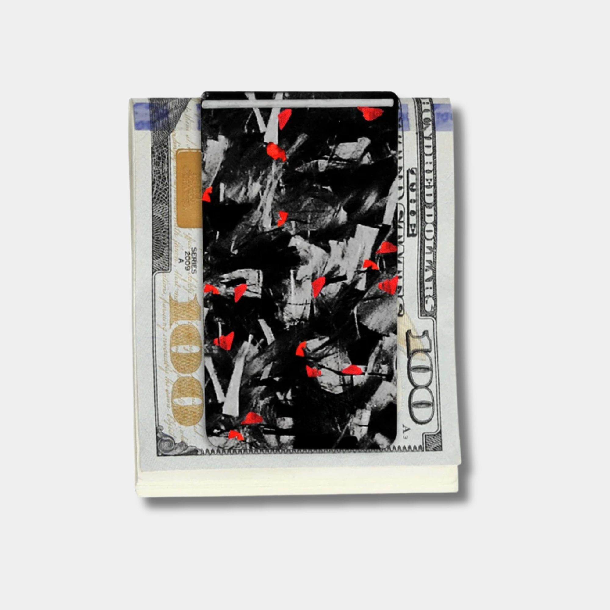 Forged Karbon™ money clip in black composite with red accents holding bills by Karbon Technik.