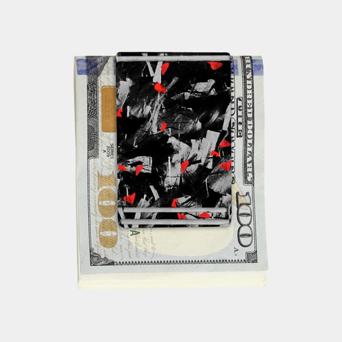 Forged Karbon™ money clip in black composite with red accents holding bills by Karbon Technik.